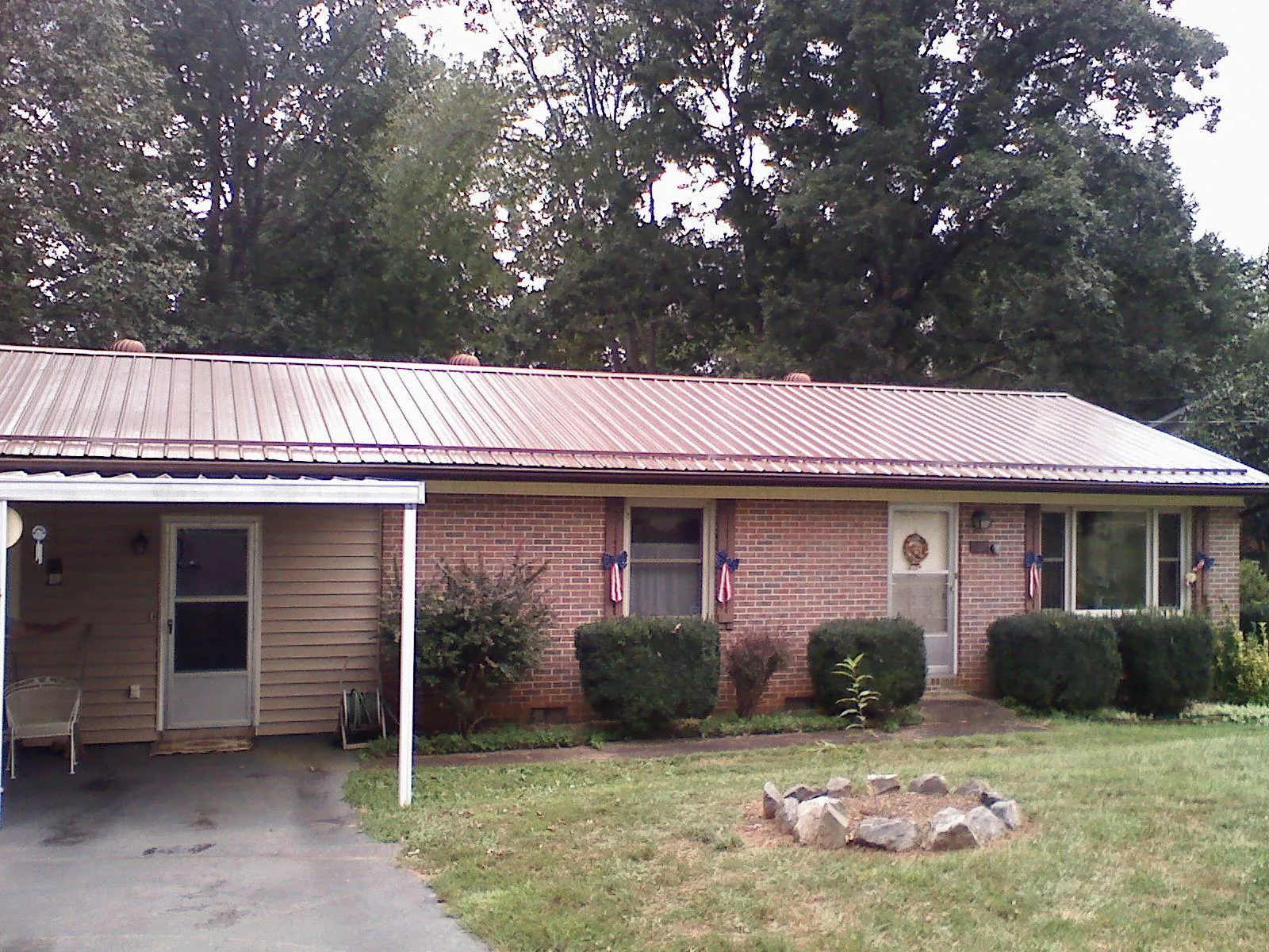 Bronze metal roof and carport on a brick ranch home — Roof Repair work by our crew in Harbor View